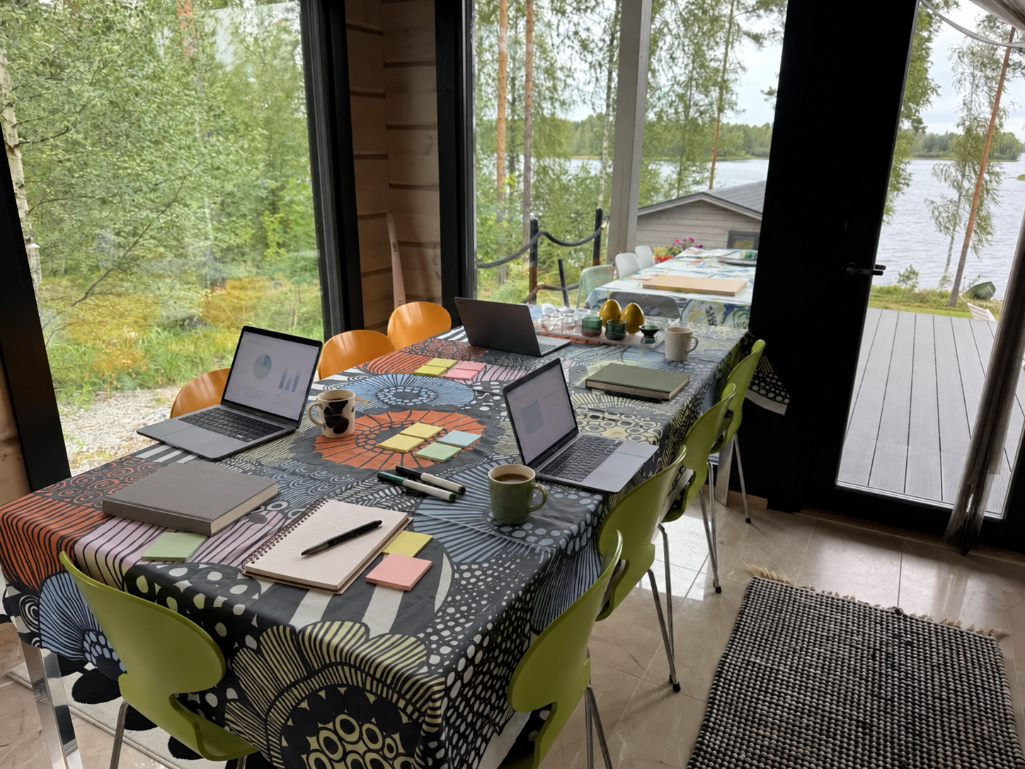 Kannettavia tietokoneita, muistikirjoja, tarralappuja ja työpajatarvikkeita Villa Foxboron pöydällä